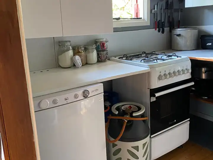 Kitchen corner with stove, gas canister and fridge