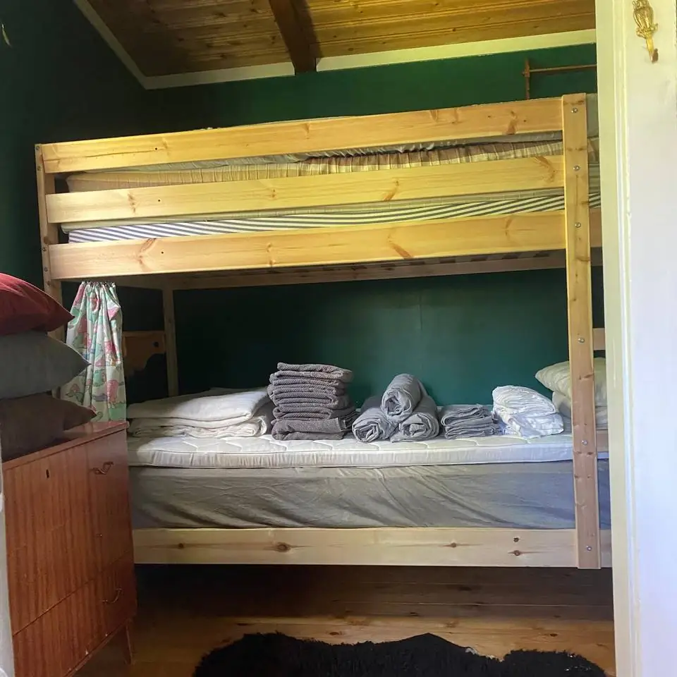 The wooden bunk bed, made up with sheets